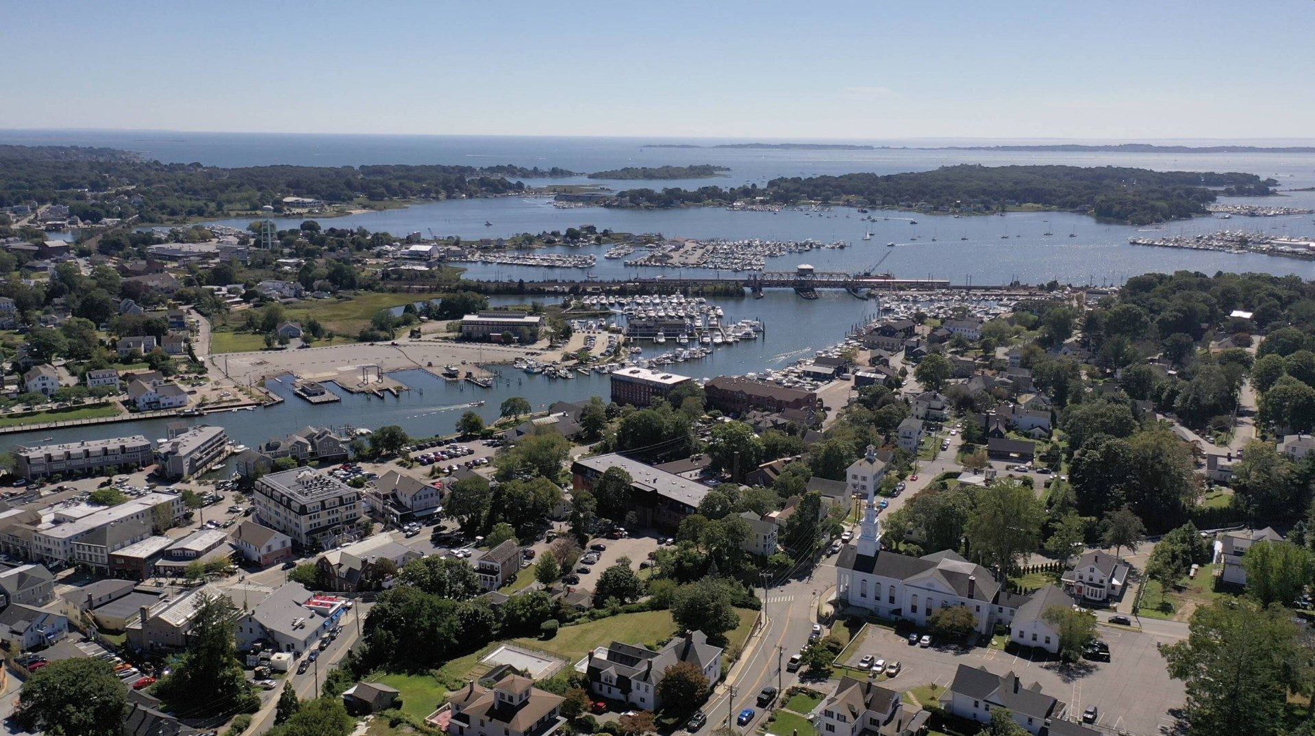 Aerial photograph of Mystic harbor with marinas, sailboats, and the Mystic River meeting Fishers Island Sound